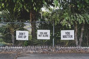 Abuse and trauma victims need positive support and care. Three signs say "don't give up" and other positive messages. Our mental health CE courses give you insight into people suffering from abuse and trauma.