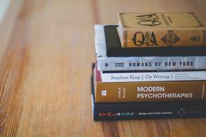 antique and modern psychotherapy books on a desk represent the continuing education process. Counselling requires constant renewal, both in our education and of our internal energy to be a force for change in our clients.